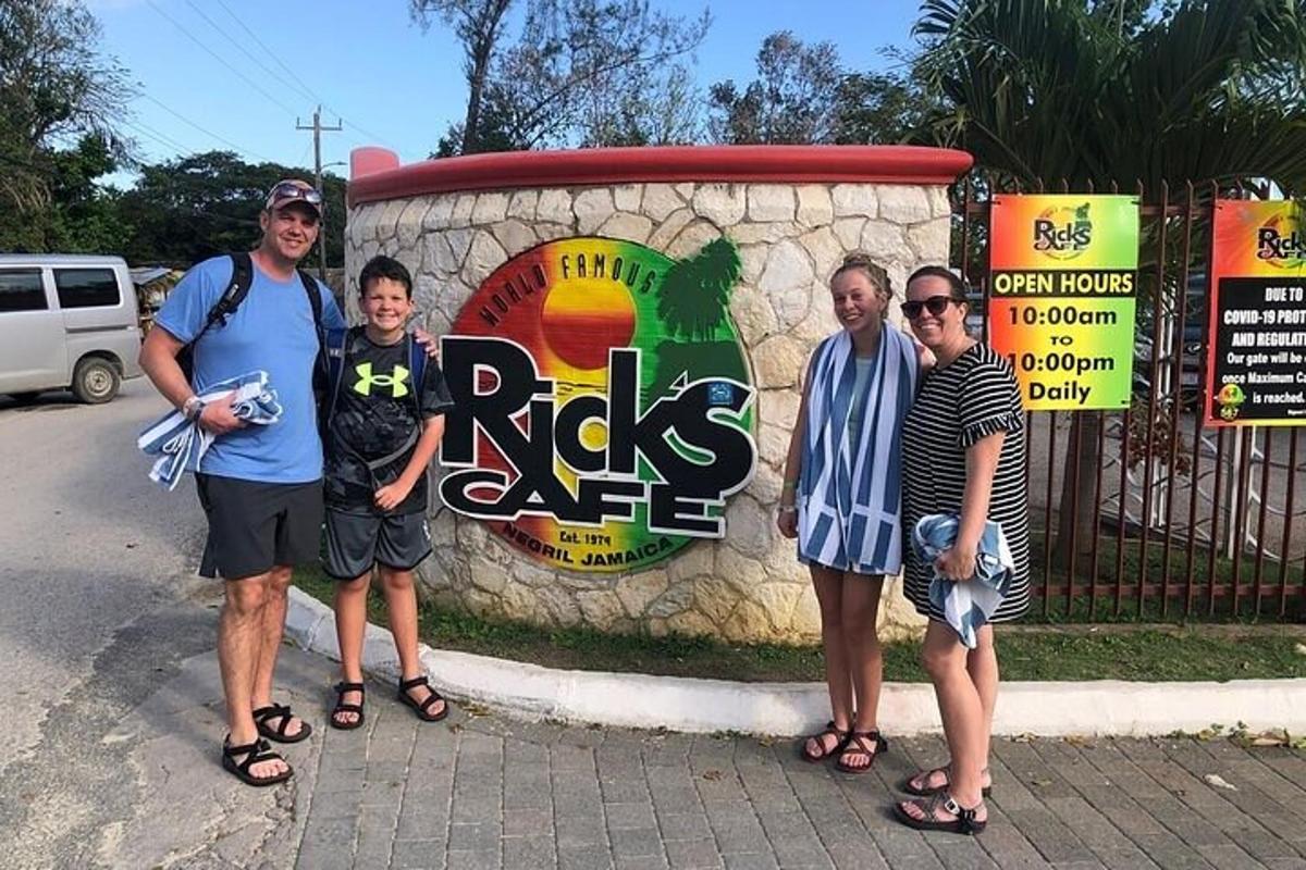 um grupo de pessoas em pé em frente a uma placa