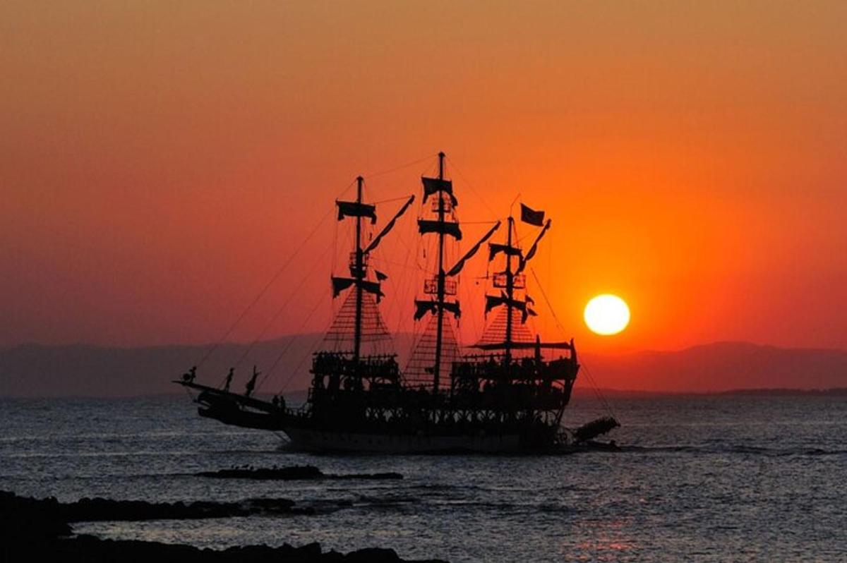 pirátská loď v oceánu při západu slunce