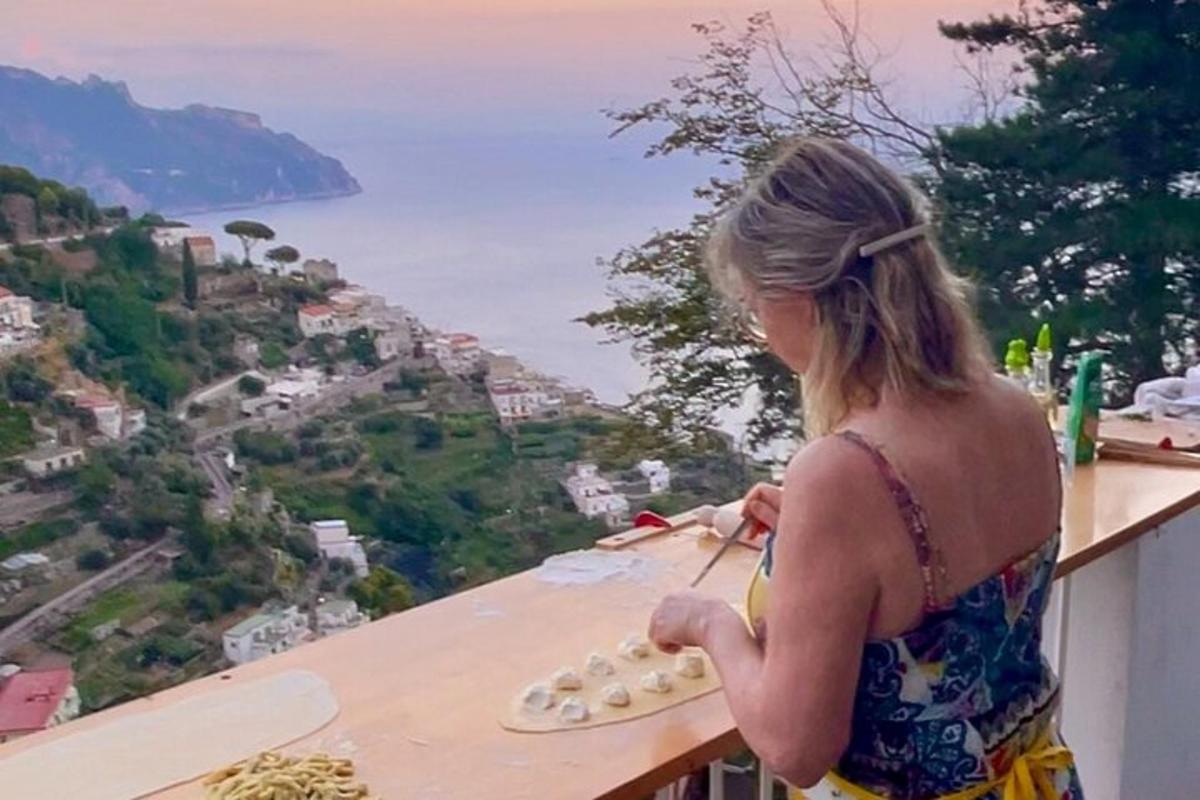 una donna in piedi su un balcone con vista sull'oceano