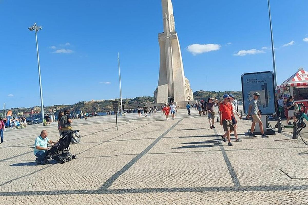 skupina lidí kráčejících před památníkem