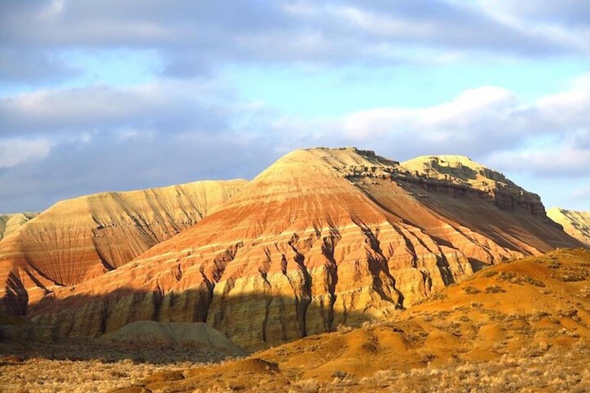 een berg in de woestijn met een bewolkte lucht
