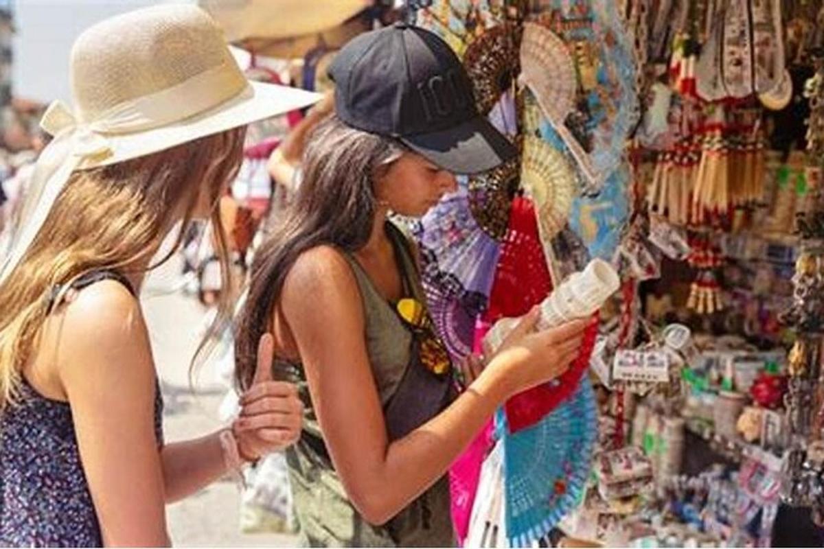 Dos mujeres jóvenes miran un expositor en una tienda.