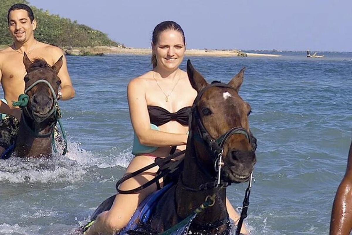 žena v bikinách jedoucí na koni ve vodě