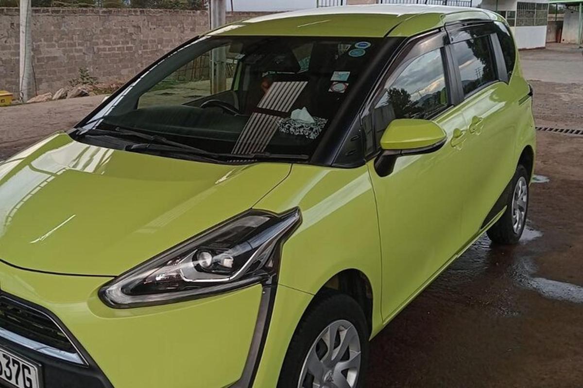 a small green car parked in a parking lot