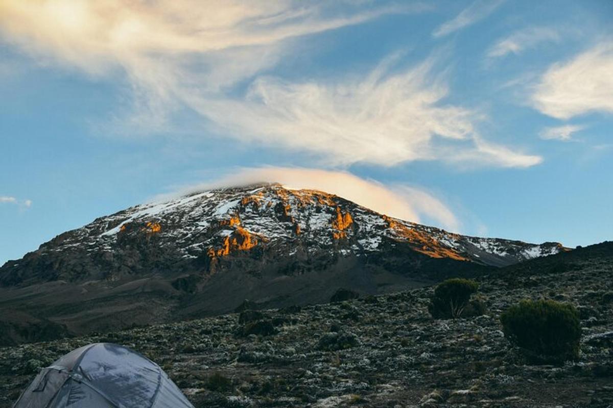 uma barraca em frente a uma montanha coberta de neve