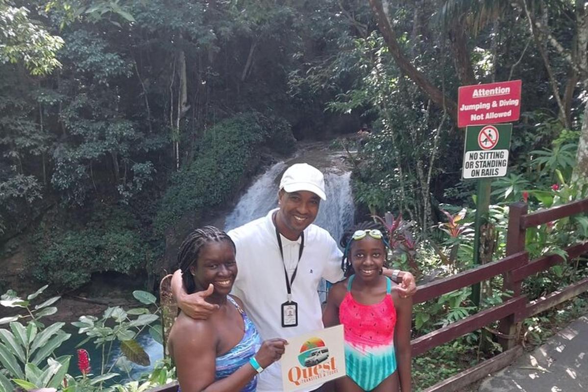 un uomo e due bambini in piedi davanti a una cascata