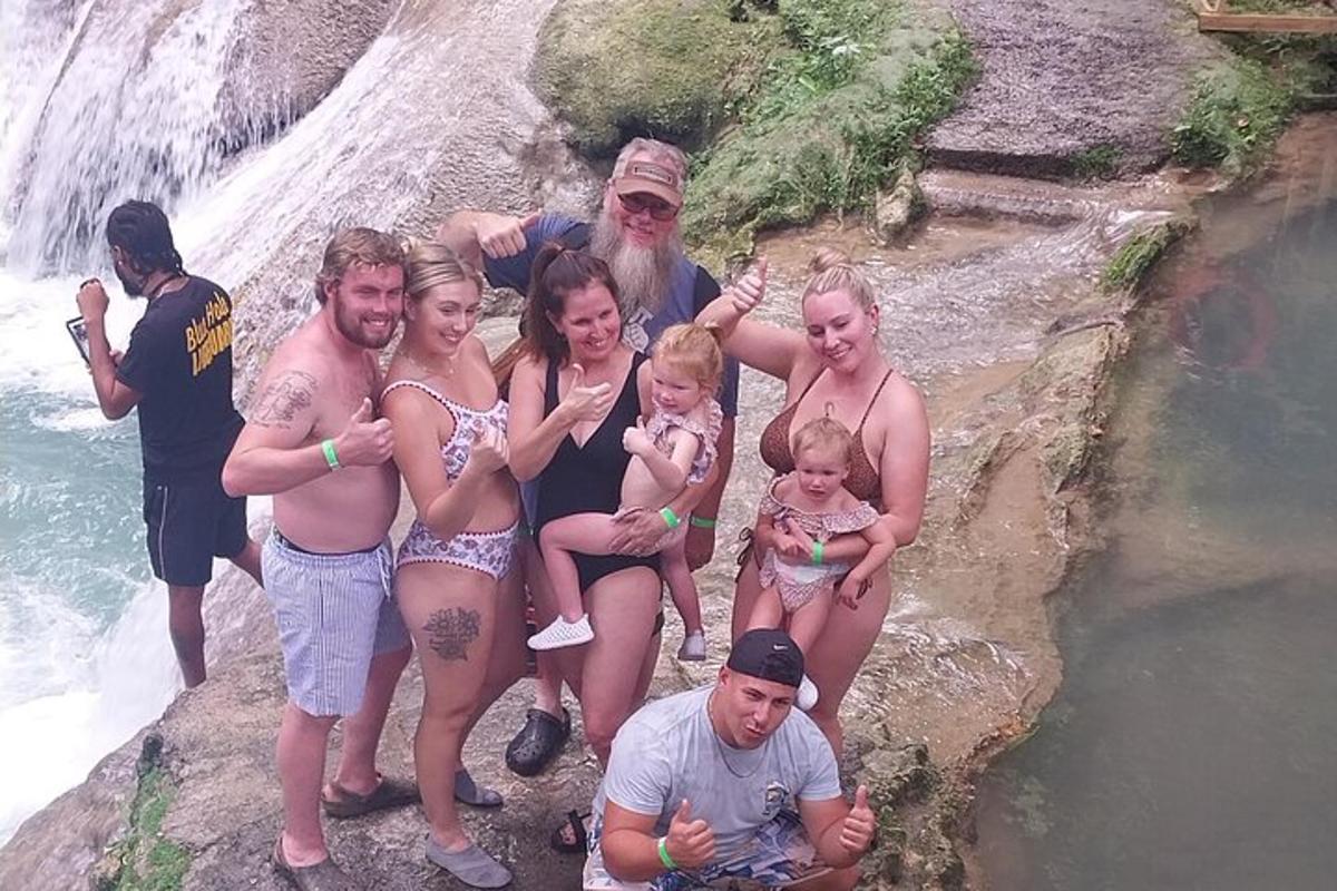 un gruppo di persone in posa davanti a una cascata