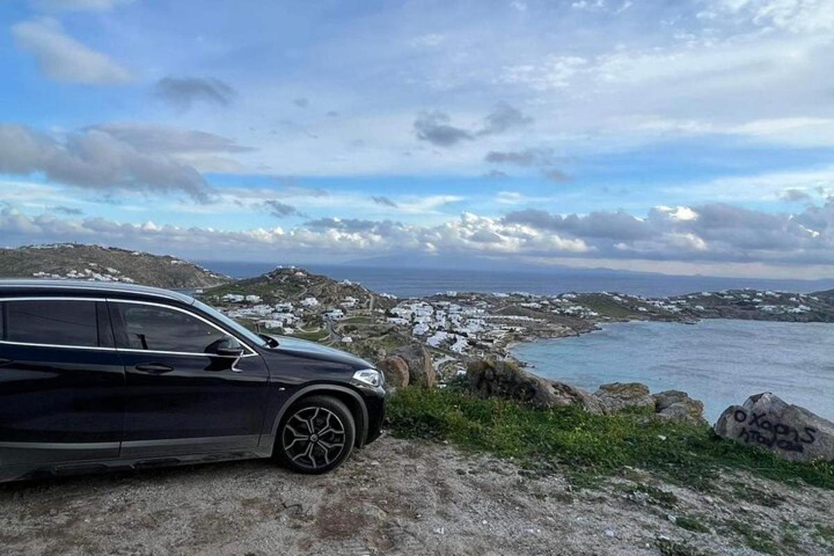 un'auto parcheggiata in cima a una roccia vicino all'oceano