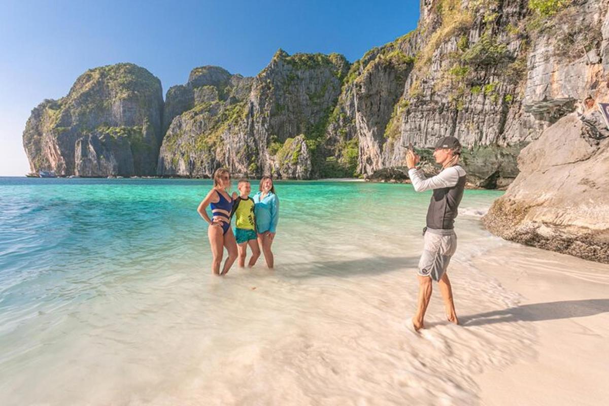 seorang lelaki mengambil gambar tiga orang di pantai