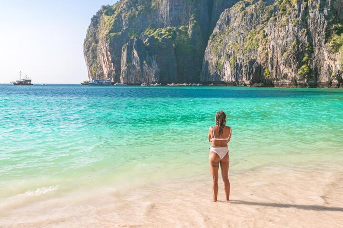 seorang wanita berdiri di pantai berhampiran air