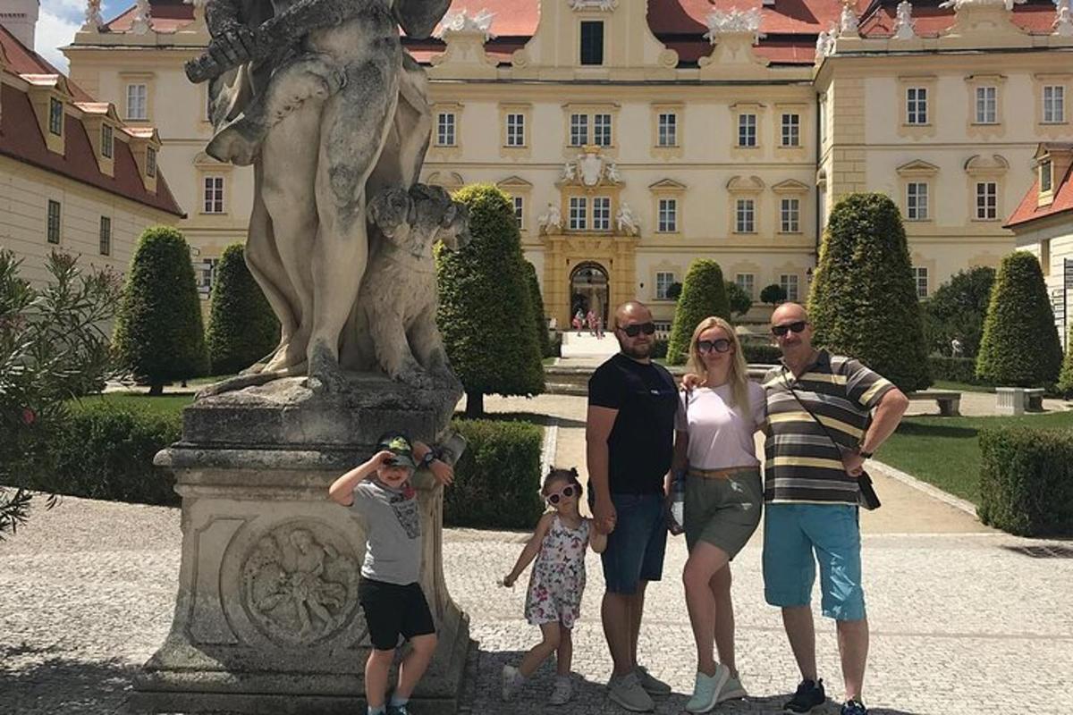 породица стоји испред статуе испред зграде