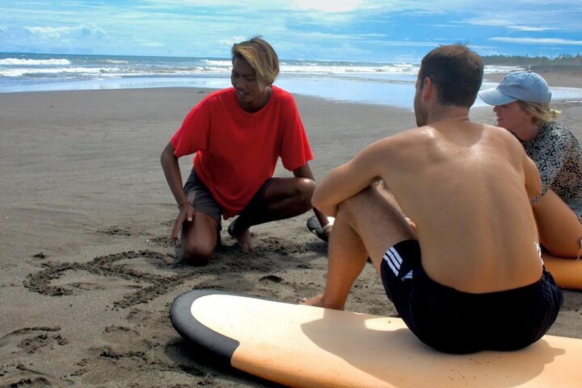 a group of people sitting on the beach with surfboards