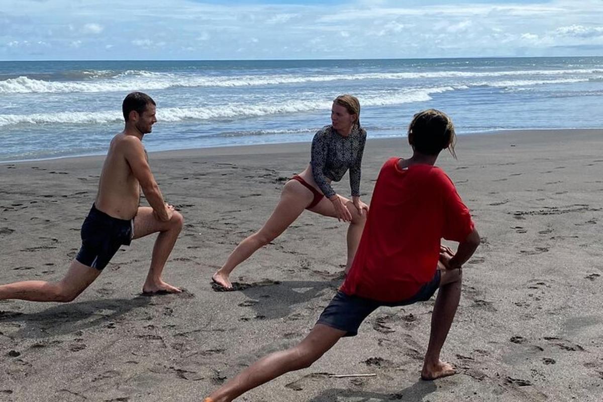 three people playing with a frisbee on the beach