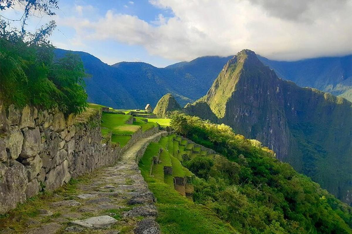 Un camino de piedra en una montaña con montañas al fondo.