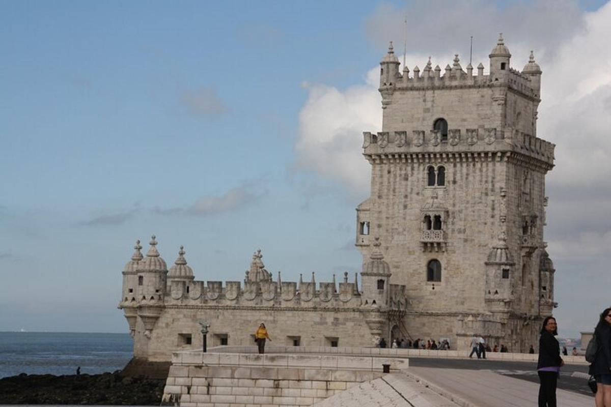 a large white castle with the ocean in the background