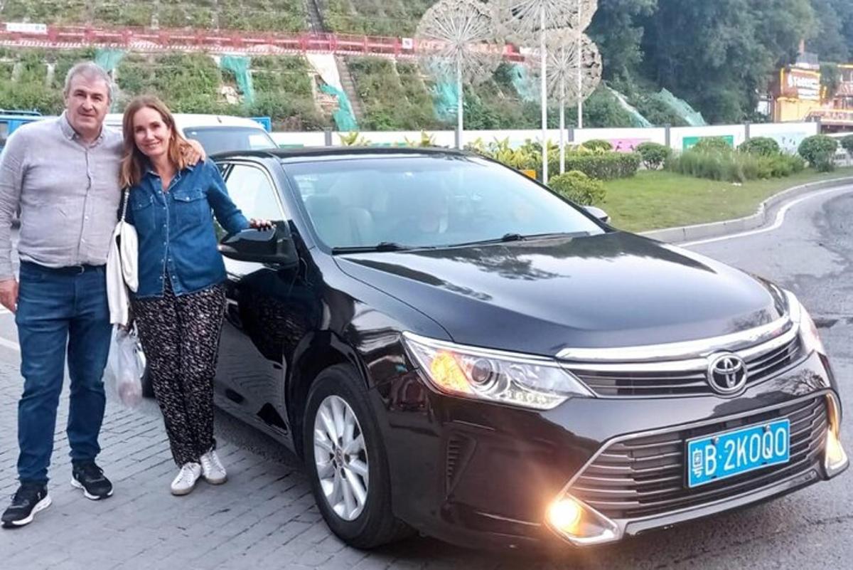 muž a žena stojící vedle auta