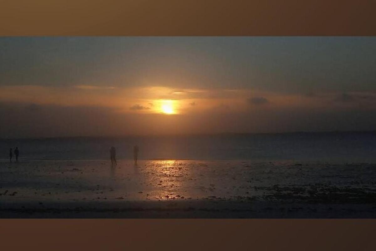 un tramonto sulla spiaggia con il sole che tramonta