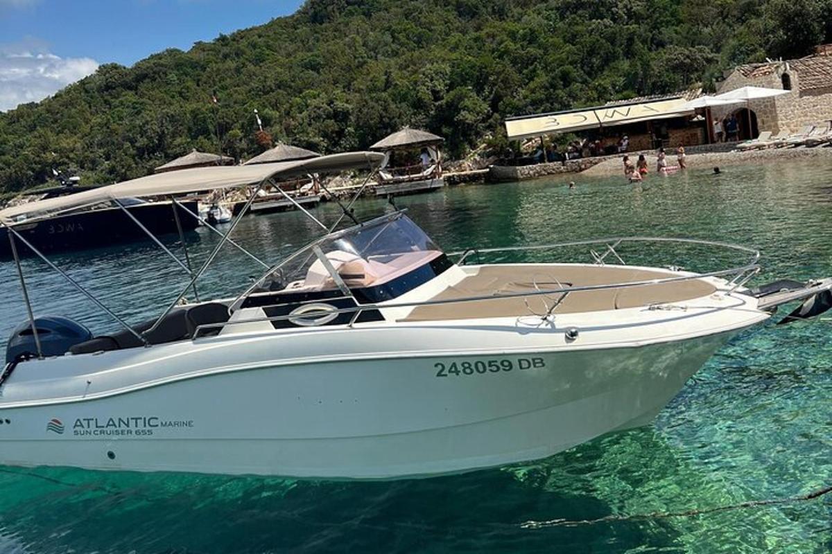 una barca bianca nell'acqua vicino a una spiaggia