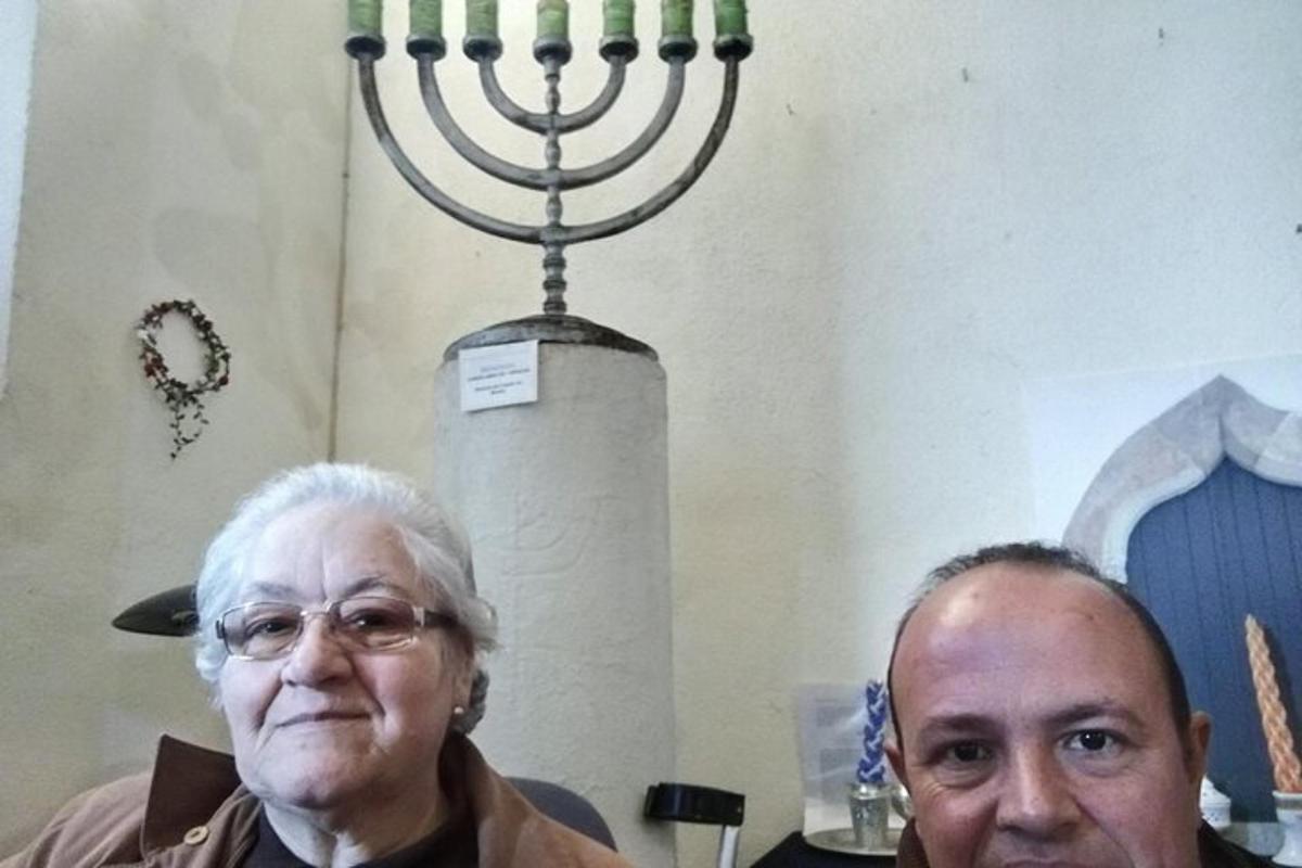 seorang pria tua berdiri di samping menorah