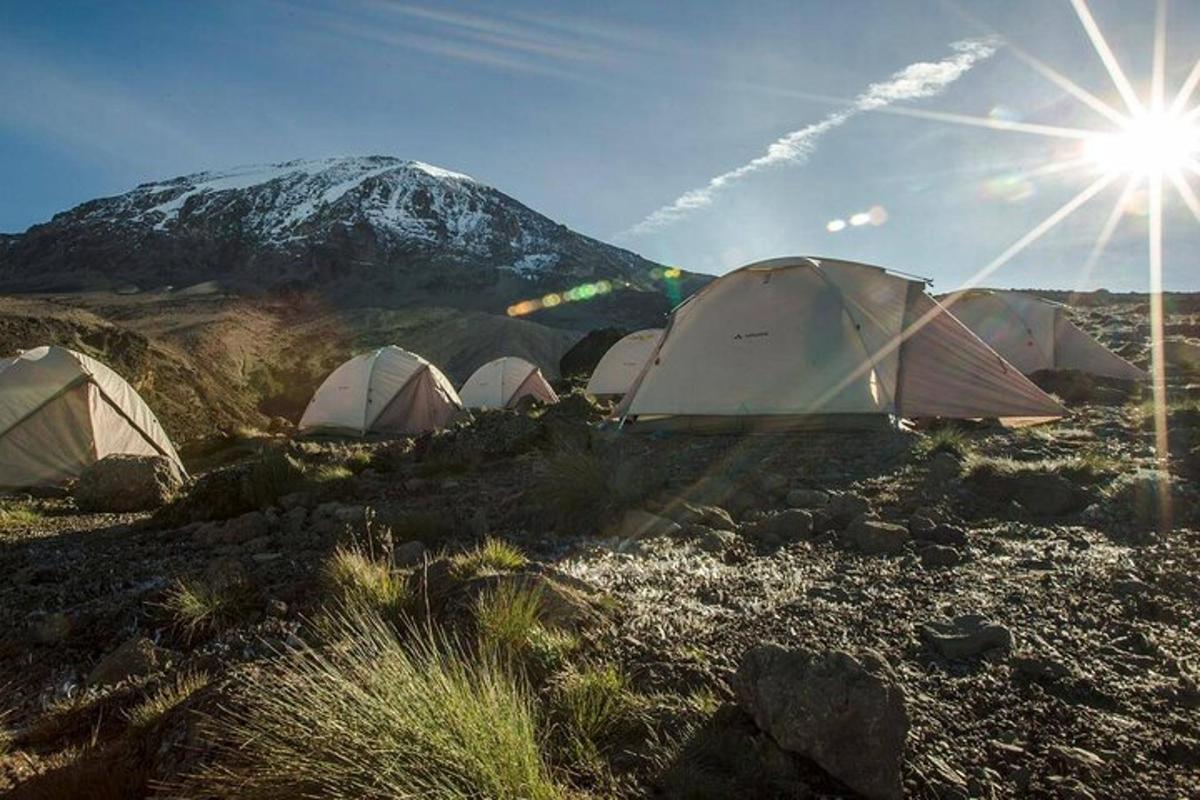 un gruppo di tende con una montagna sullo sfondo