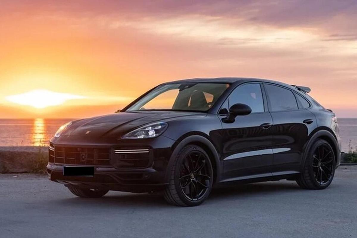 automobilis pastatytas paplūdimyje, fone – saulėlydis
