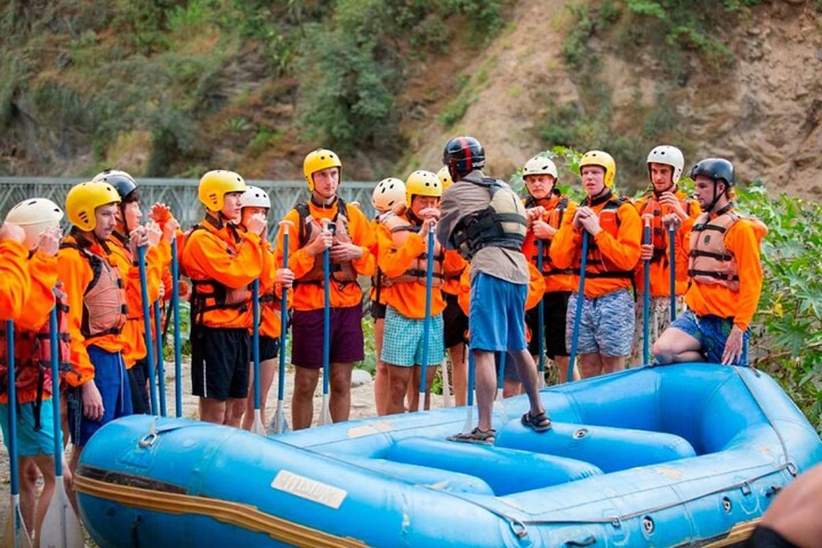un grup de persones amb jaquetes taronges al voltant d'una bassa