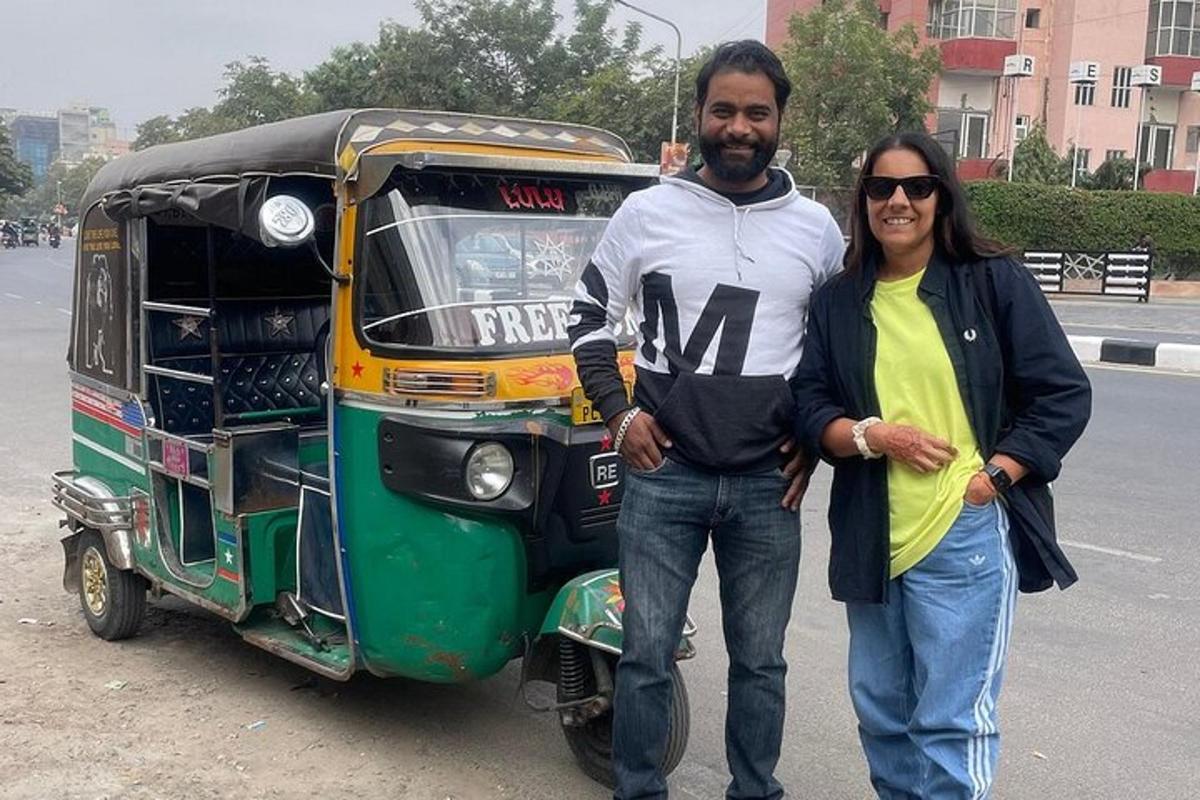 a man and a woman standing next to a small vehicle