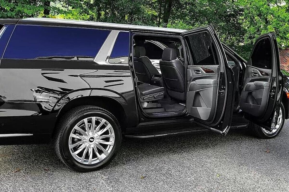 una limousine nera con la portiera aperta in un parcheggio