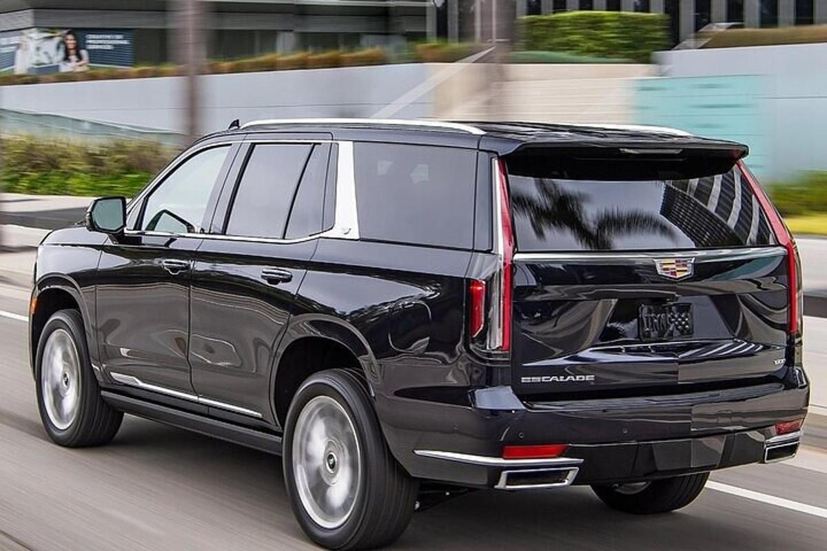 a black suv driving down a city street