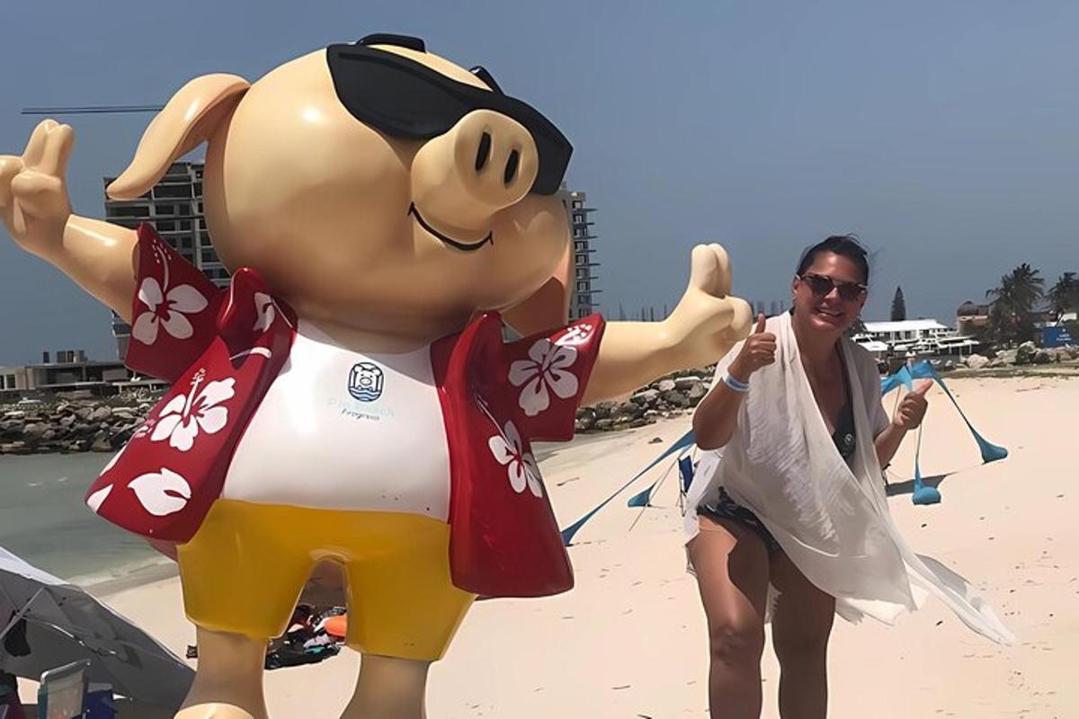 una donna in piedi accanto a un grande animale gonfiabile sulla spiaggia