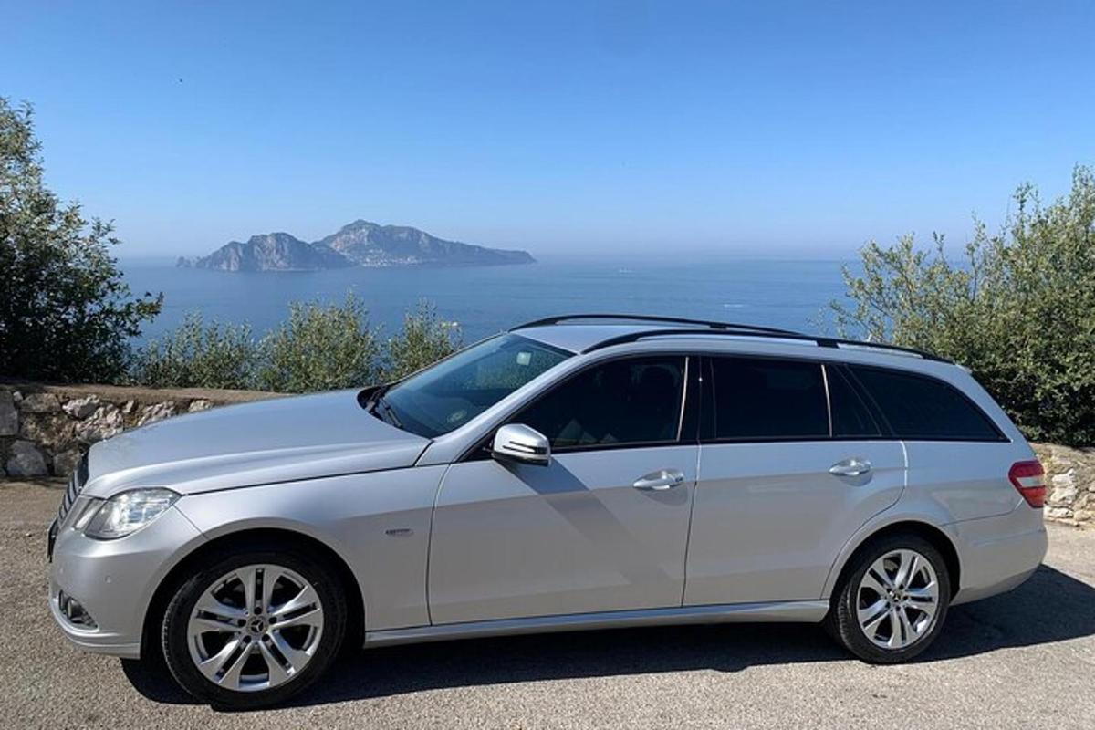ein silbernes Auto, das neben dem Meer geparkt ist