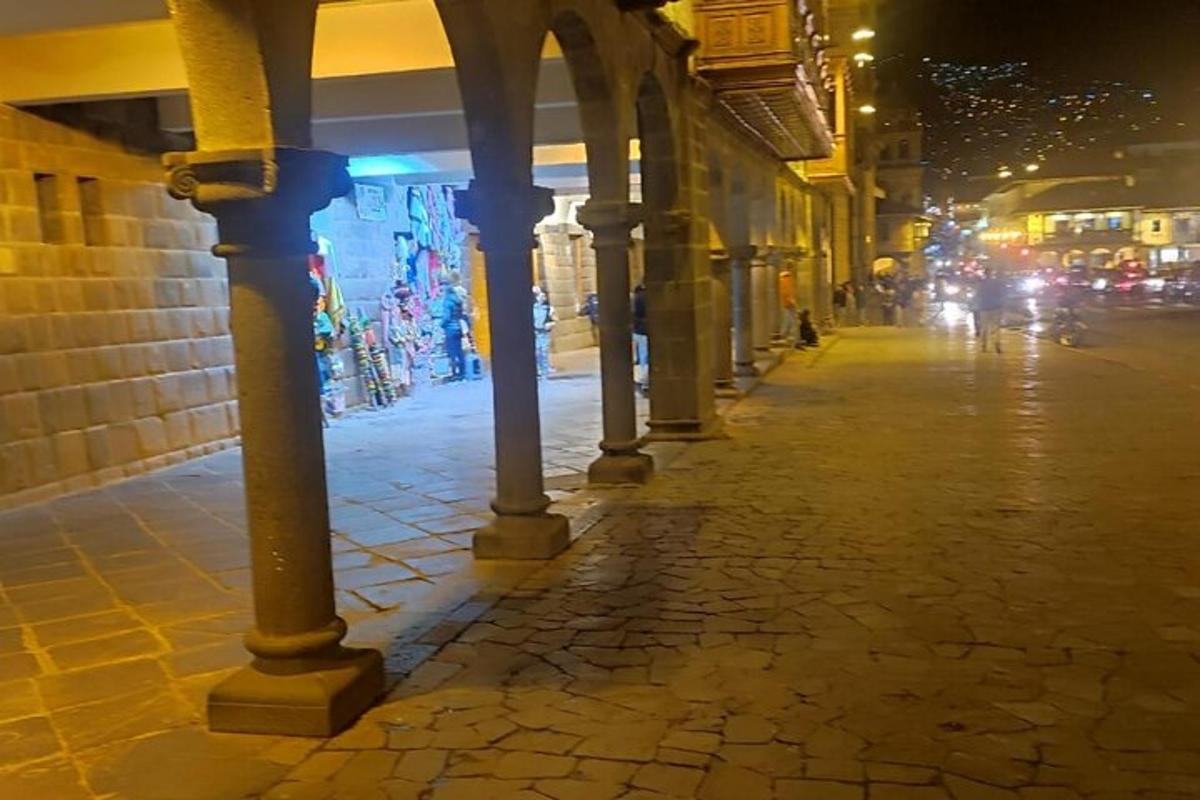 una fila de columnas en una calle por la noche