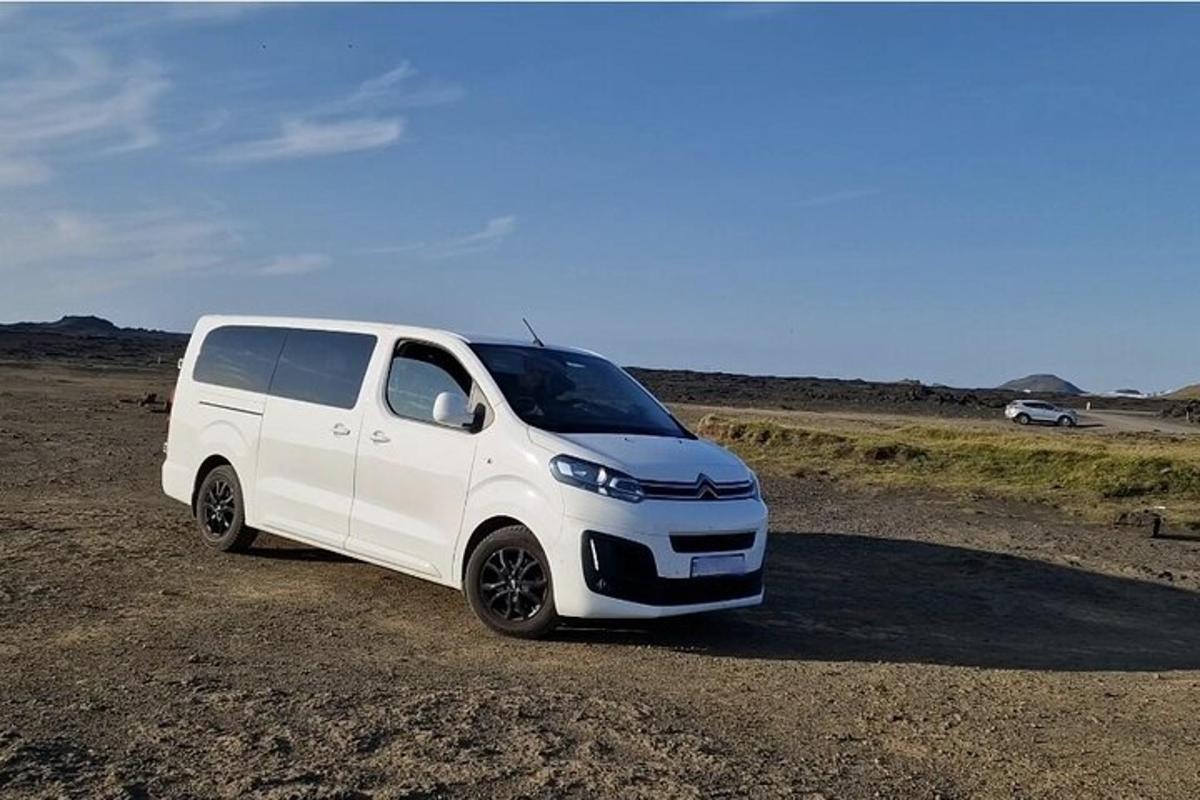 uma van branca estacionada em um campo de terra