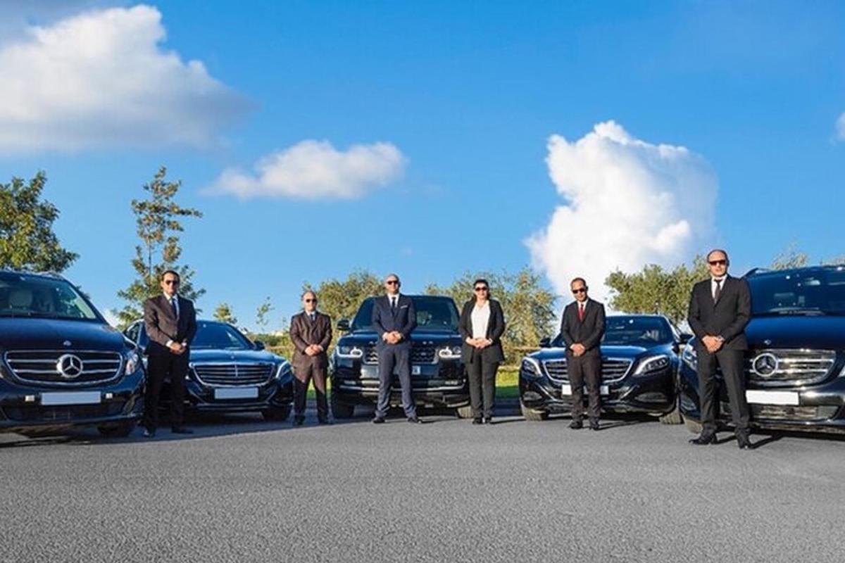 egy csoport férfi luxusautók előtt áll