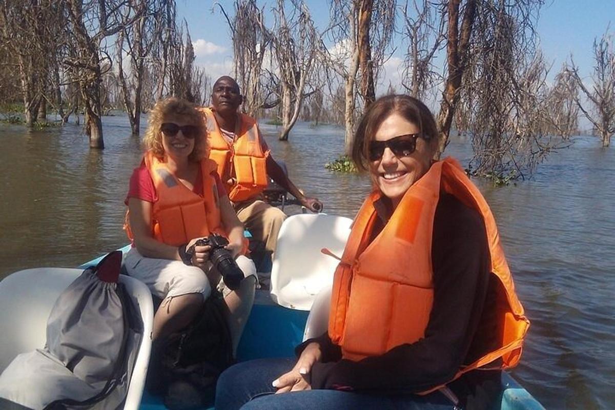 tre donne con giubbotti di salvataggio su una barca in acqua