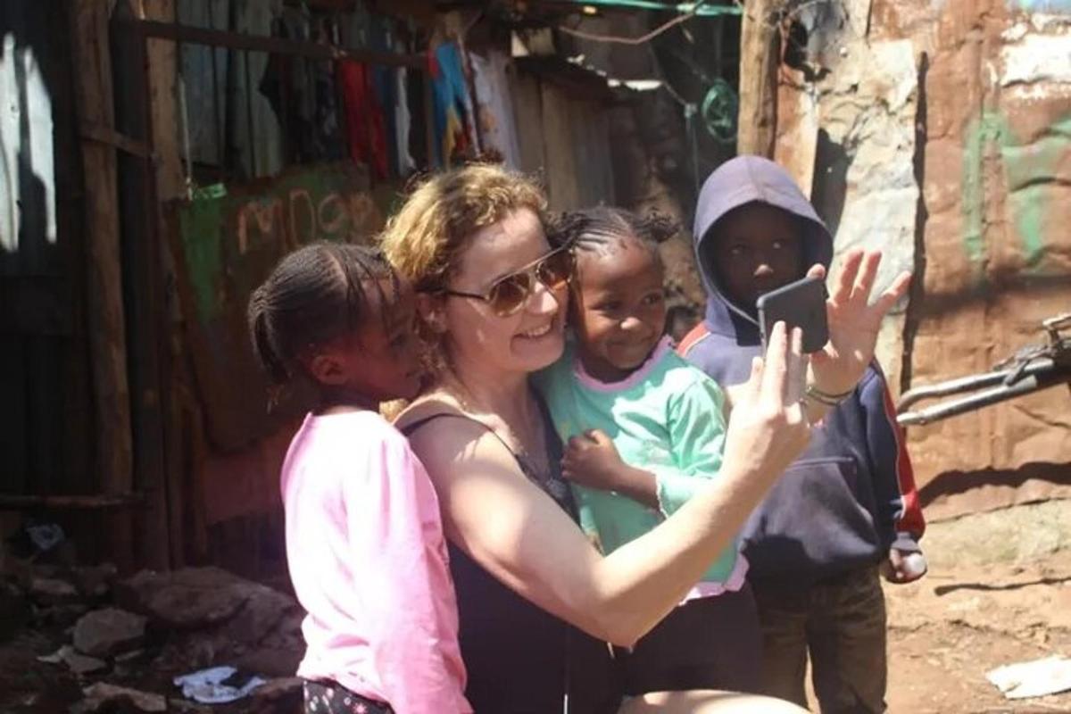 a woman taking a picture of a group of children