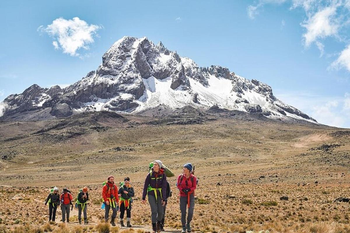 isang grupo ng mga taong naglalakad sa harap ng isang bundok