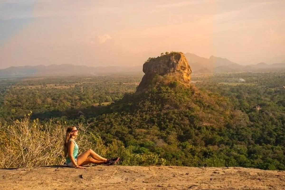 a woman sitting on top of a rock