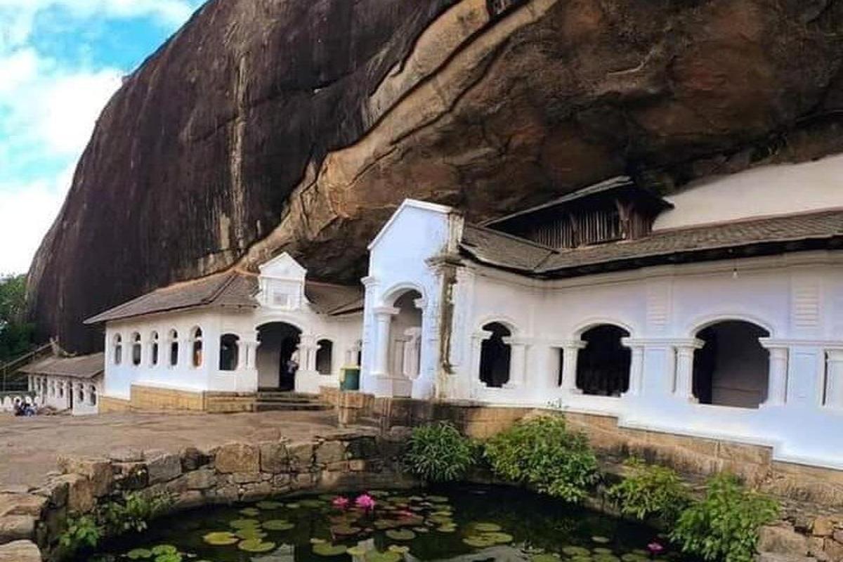 a building in front of a mountain with a pond