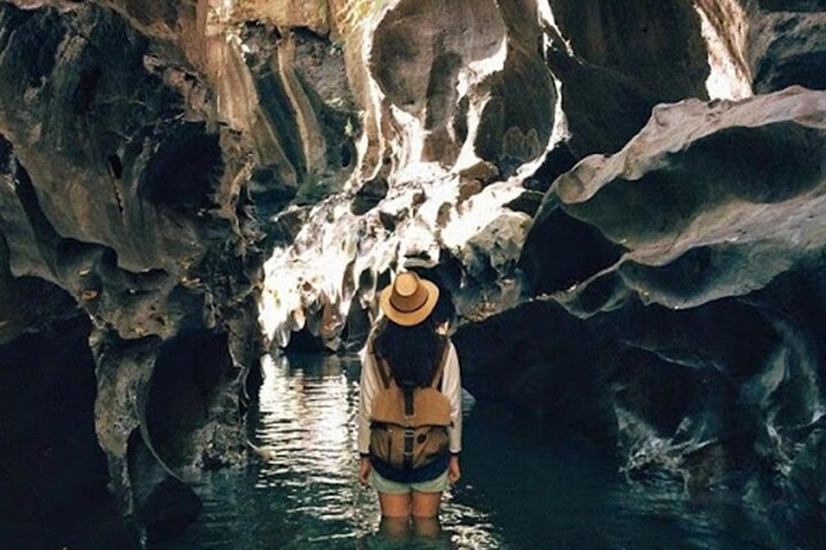 Un hombre parado en una cueva en el agua.