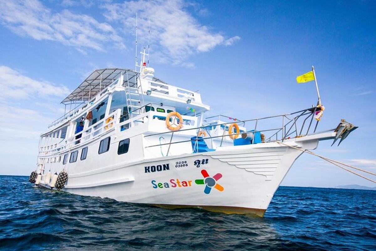 un barco blanco en el océano con una bandera amarilla