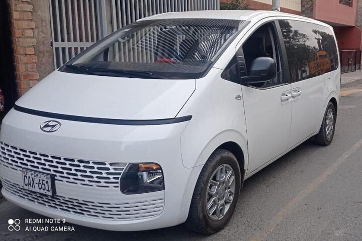 sebuah mobil van putih diparkir di pinggir jalan