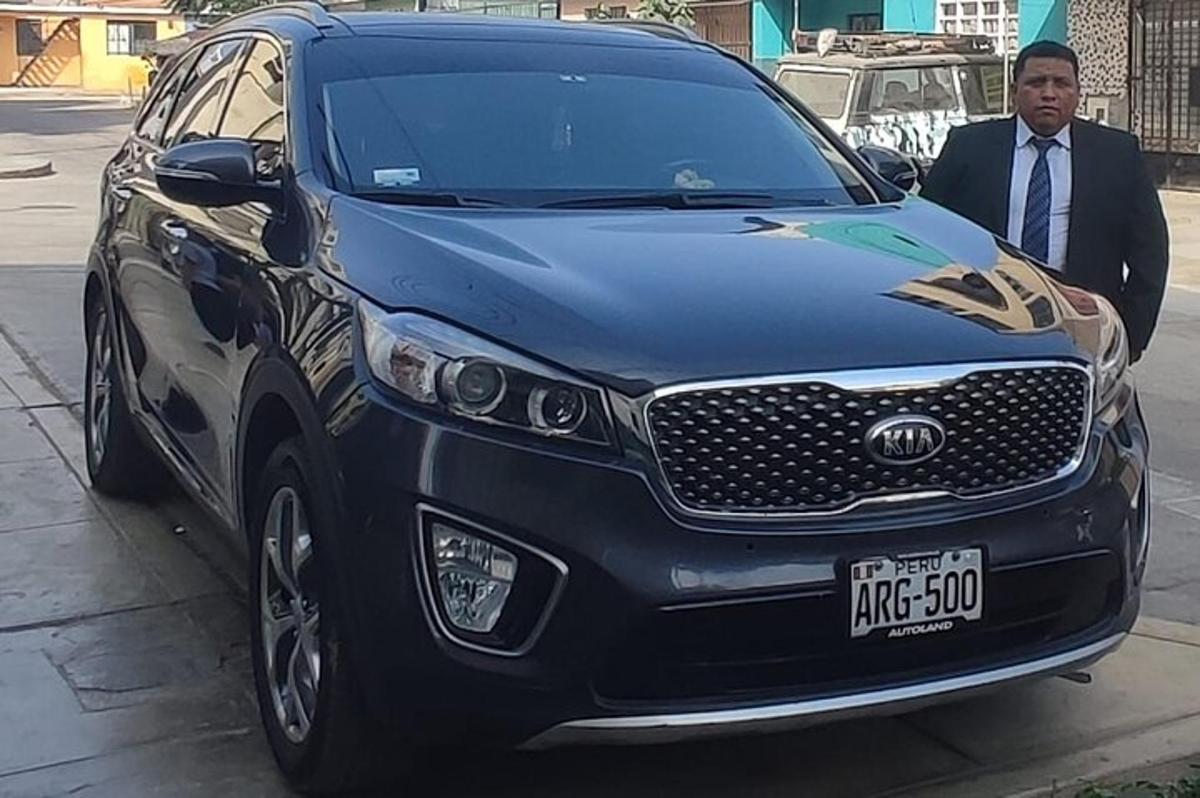 a man is standing next to a black car