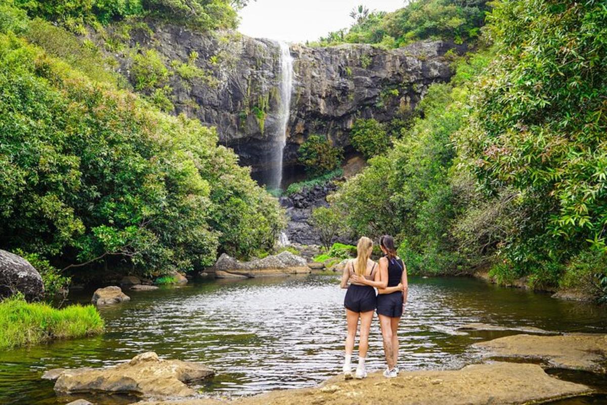 due donne in piedi nell'acqua vicino a una cascata