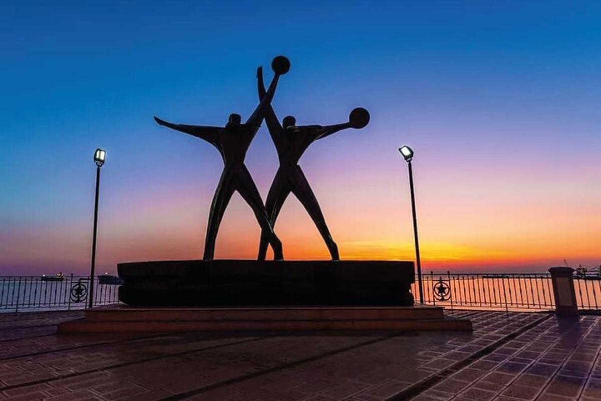 两人站在日落前的雕像