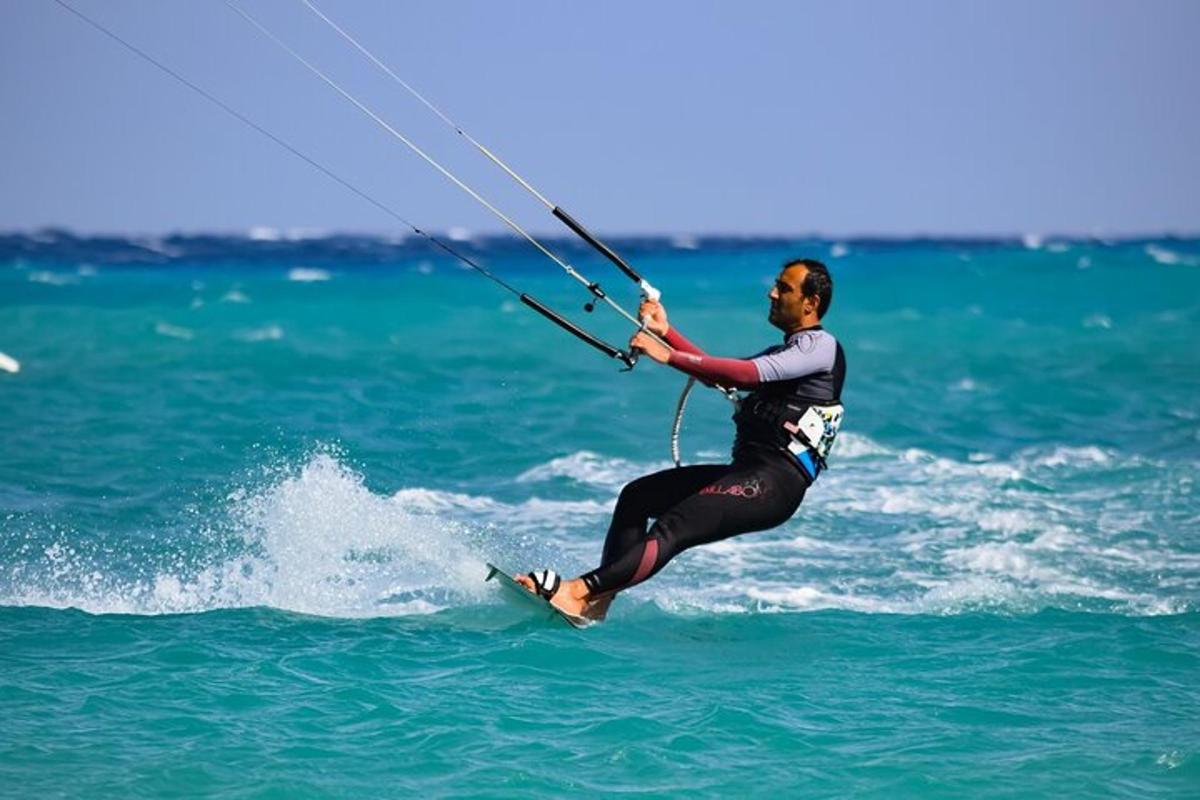 a man in the ocean holding on to a rope