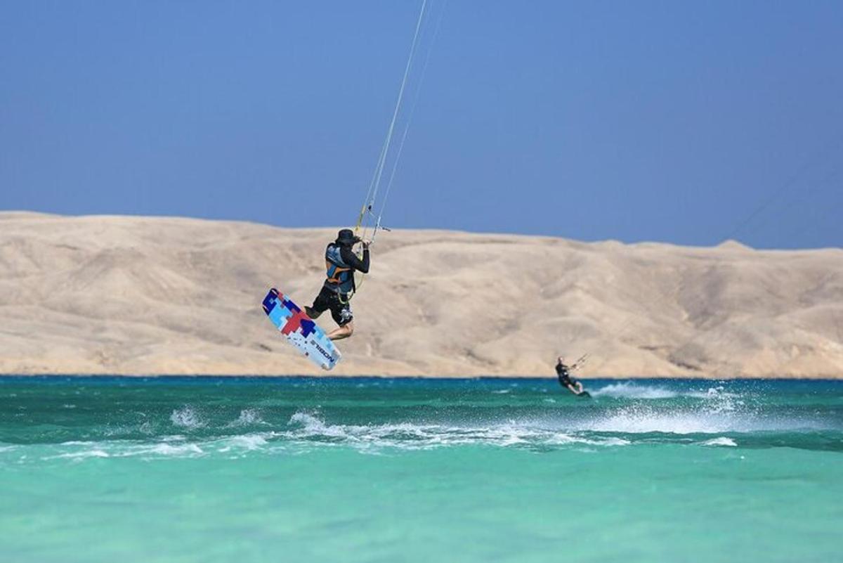 Maður flýgur um loftið á meðan hann er að kitesurfa í sjónum