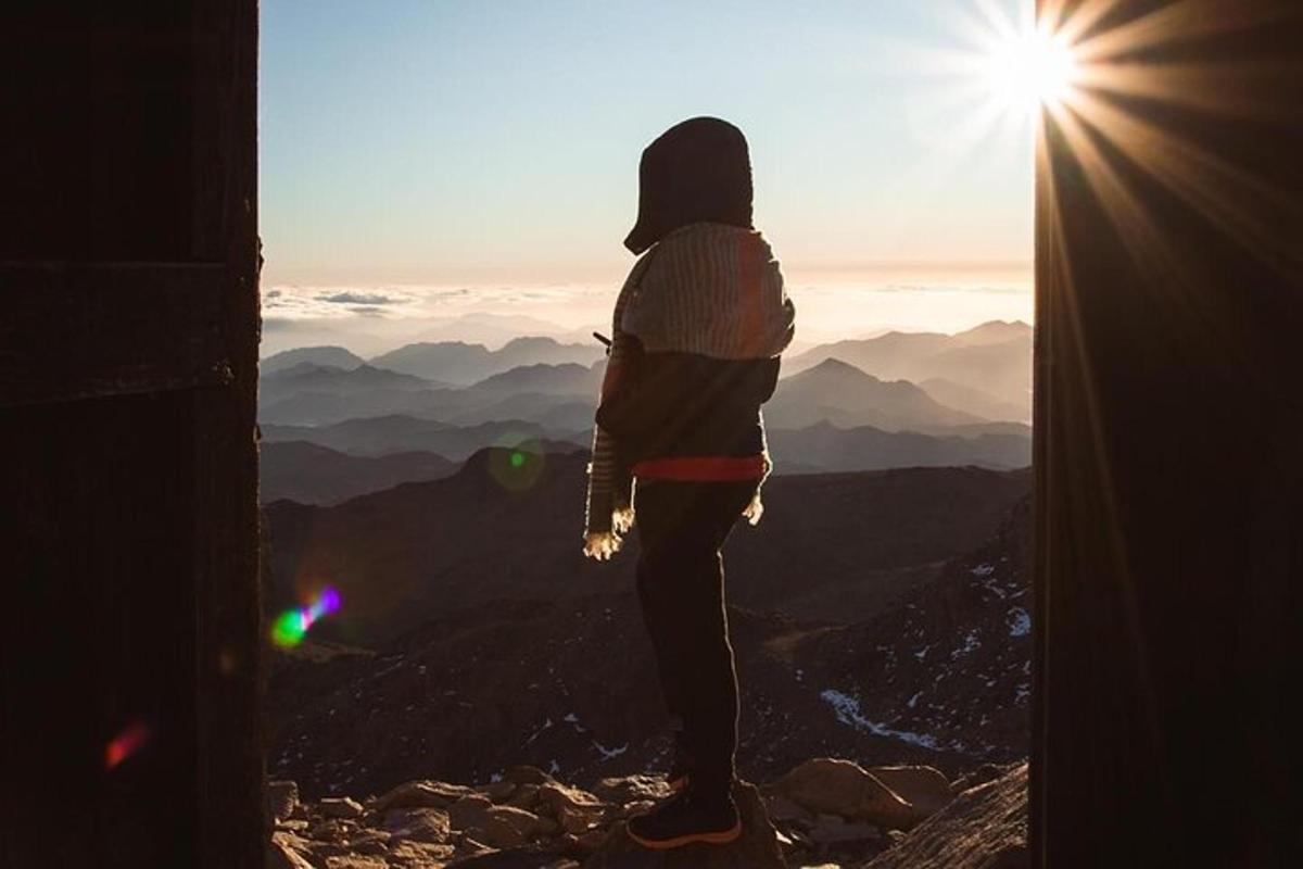 seseorang yang berdiri di puncak gunung