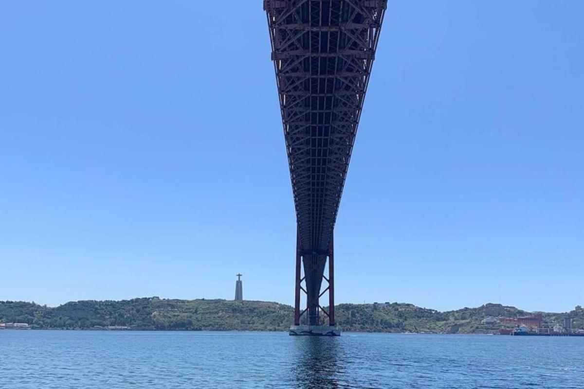 un ponte sull'acqua con un faro sullo sfondo