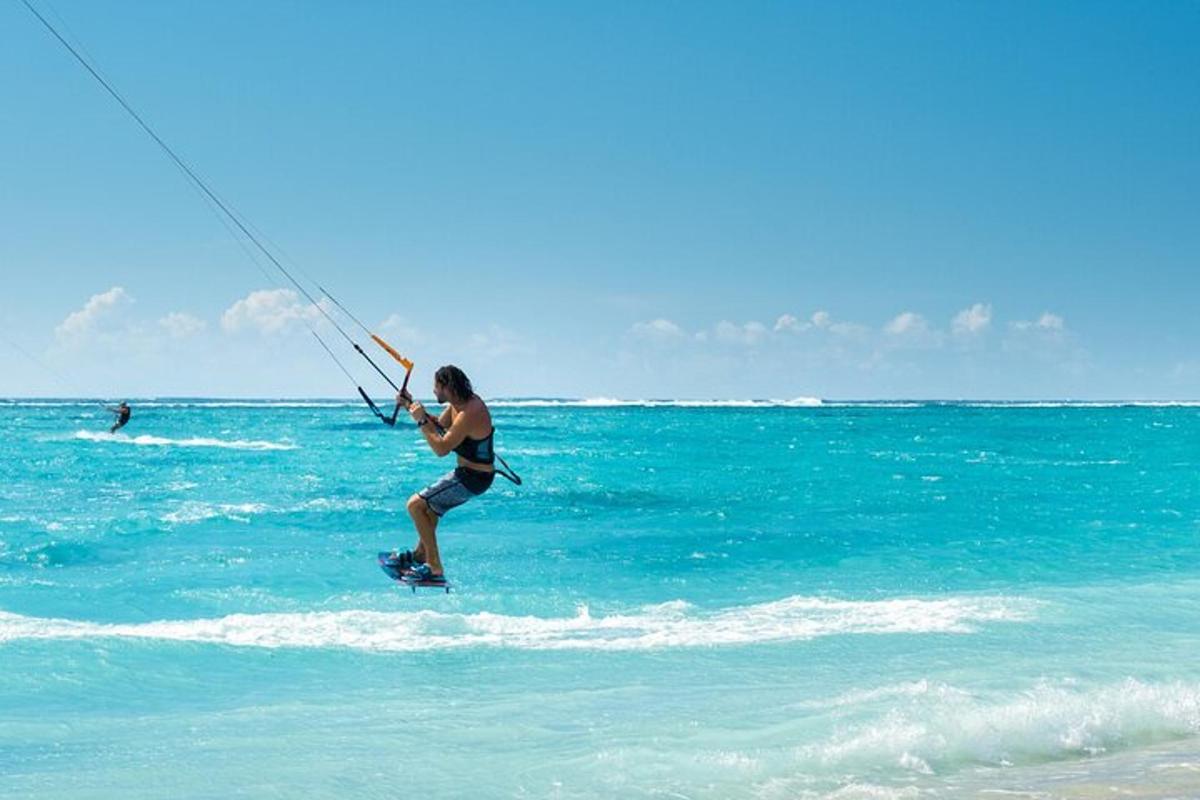 Ένας άντρας κάνει kitesurf στον ωκεανό στην παραλία